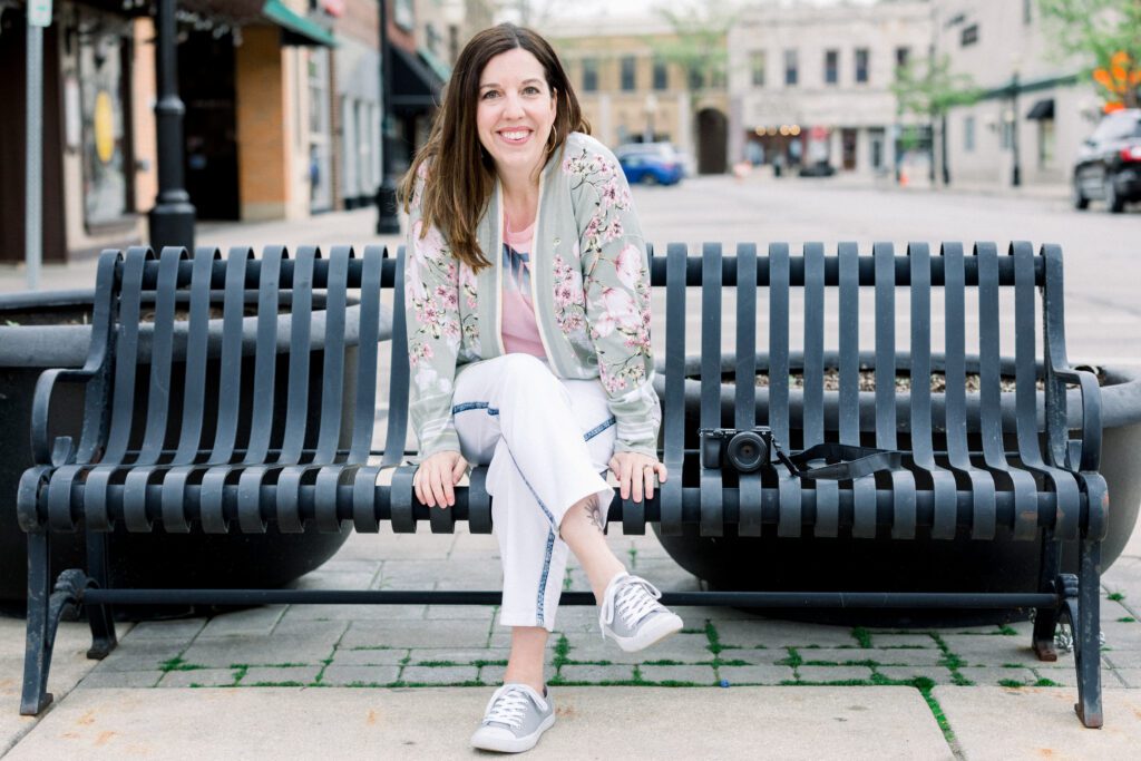 woman on a park bench wearing white jeans and a floral cardigan | Allison Scholes testimonial for Gina Forcatto